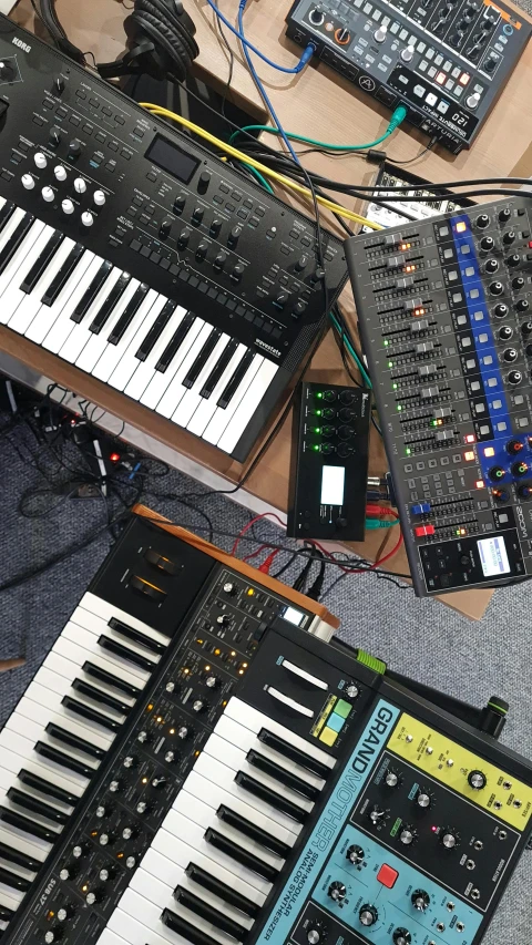 a bunch of electronic keyboards sitting on top of a table, reddit, assemblage, bass sound waves on circuitry, drone shot, devices and instruments, portrait of gigachad