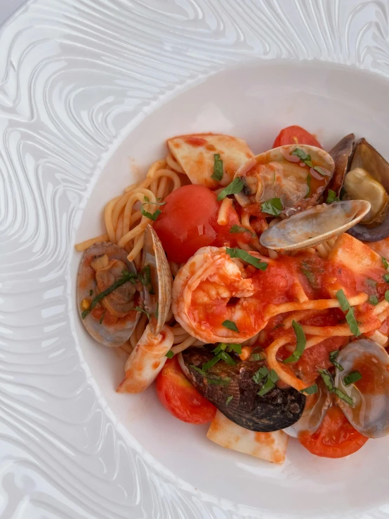 a white bowl filled with pasta and clams, a portrait, by Pamela Drew, pexels contest winner, square, tomato sauce, crustacean, multi - coloured