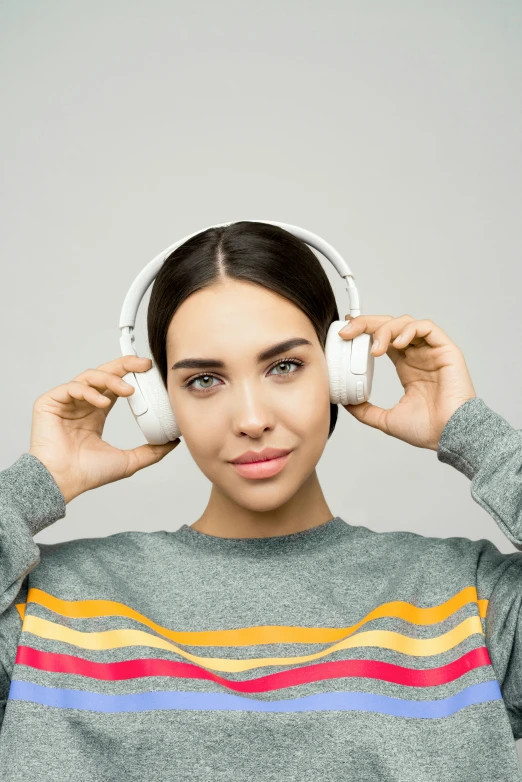 a woman with headphones covering her ears, by Adam Marczyński, wearing a white sweater, plain background, promo image, multiple stories