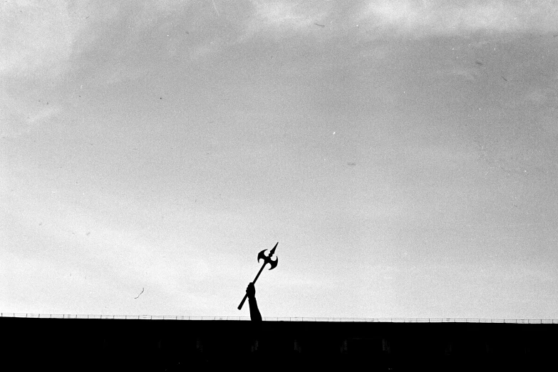 a black and white photo of a person flying a kite, a black and white photo, by Zsolt Bodoni, cinematic. by leng jun, art sussman, in the style saul bass, silhoutte