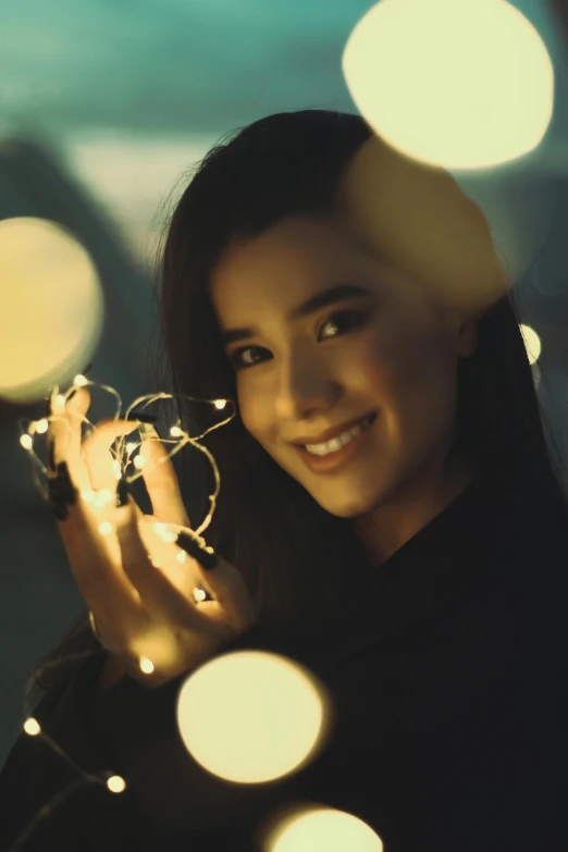 a woman holding a string of lights in front of her face, li bingbing, portrait of demi rose, color graded, light smiling