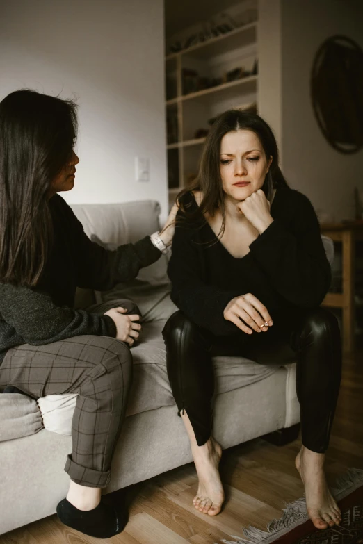 two women sitting on a couch in a living room, by Adam Marczyński, trending on pexels, with a hurt expression, talking, emily rajtkowski, supportive