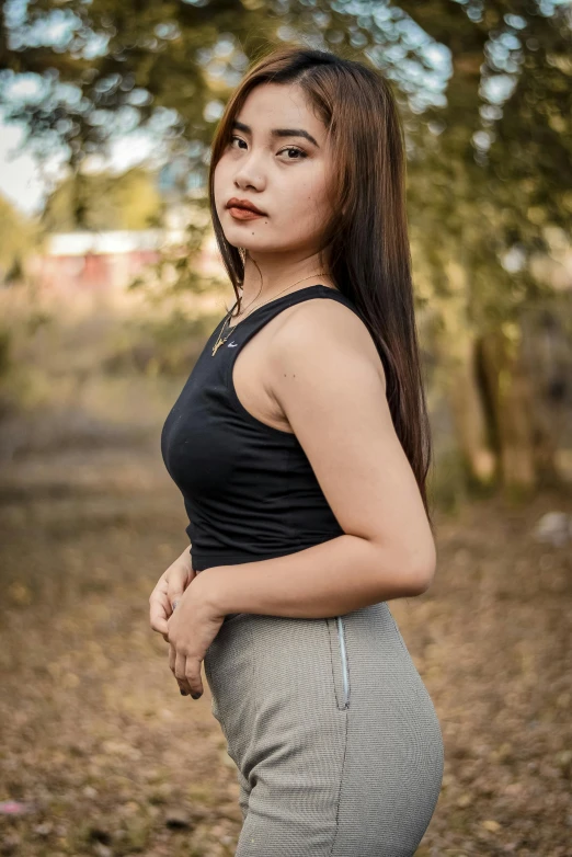 a woman in a black top and grey skirt, by Sven Erixson, unsplash, realism, south east asian with round face, tight black tank top and shorts, autum, 🤤 girl portrait