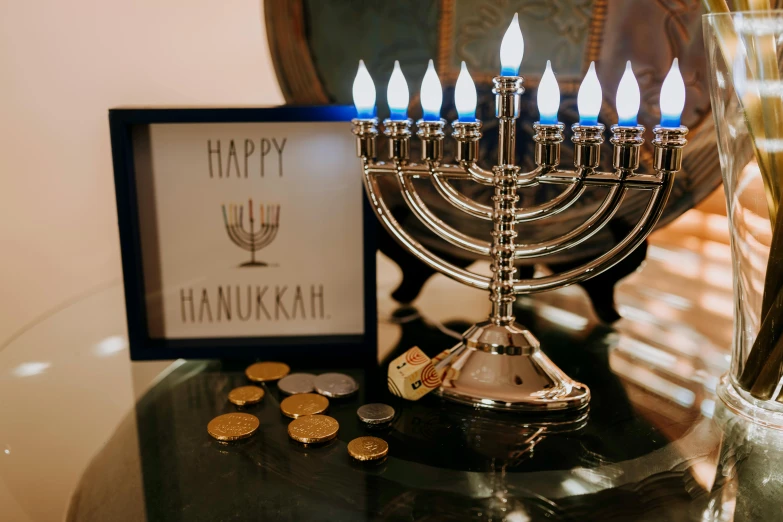 a menorah sitting on top of a table next to coins, by Julia Pishtar, pexels contest winner, hurufiyya, decoration around the room, instagram post, hannah yata charlie immer, welcoming