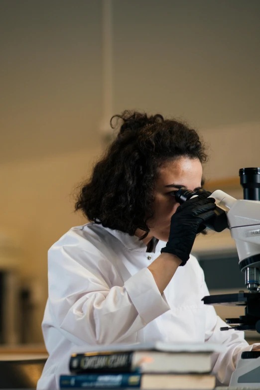 a woman in a lab coat looking through a microscope, by Anna Haifisch, pexels, riyahd cassiem, gif, high contrest, digging