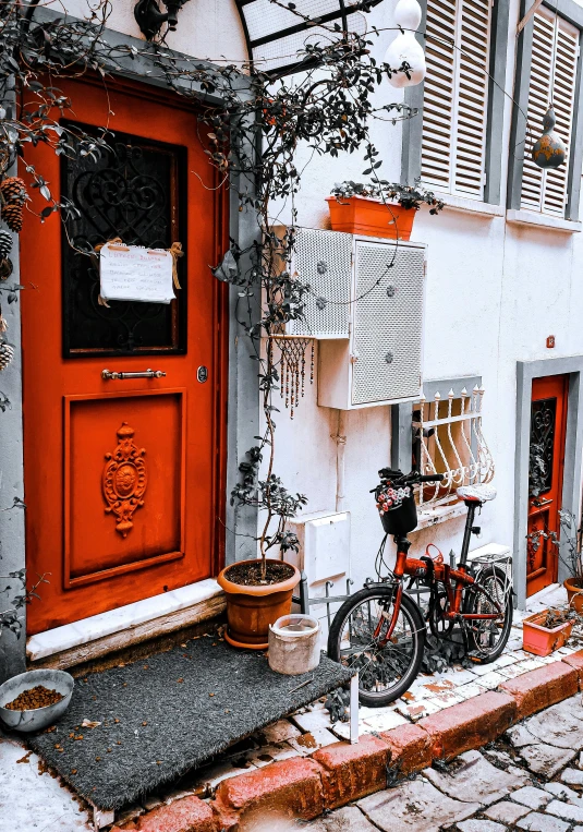 a bicycle parked in front of a red door, a photo, pexels contest winner, art nouveau, white and orange, street of hong kong, cottage, an escape room in a small