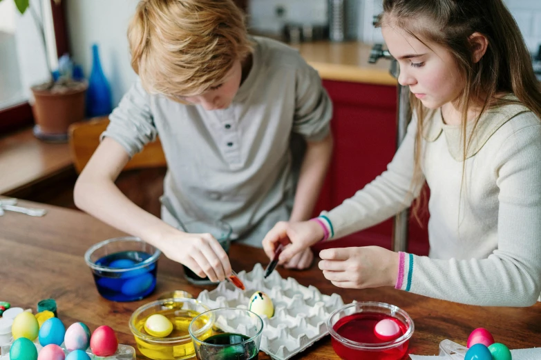 a couple of kids that are sitting at a table, trending on pexels, process art, translucent eggs, educational supplies, epicurious, kodachrome colour