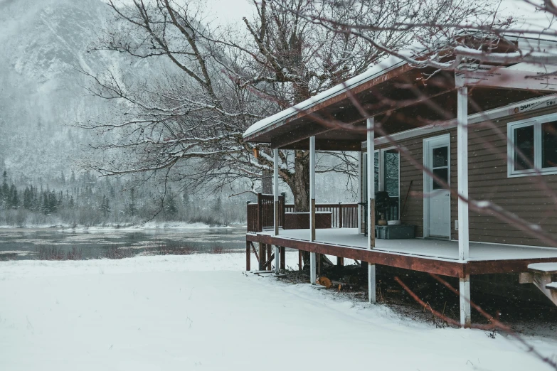 a cabin in the snow next to a body of water, by Carey Morris, pexels contest winner, with a front porch, 70s photo, white, ad image