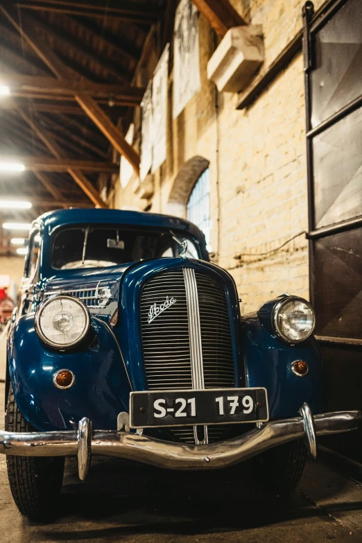 an old blue car is parked in a garage, renaissance, in chippendale sydney, indoor picture, upclose, navy