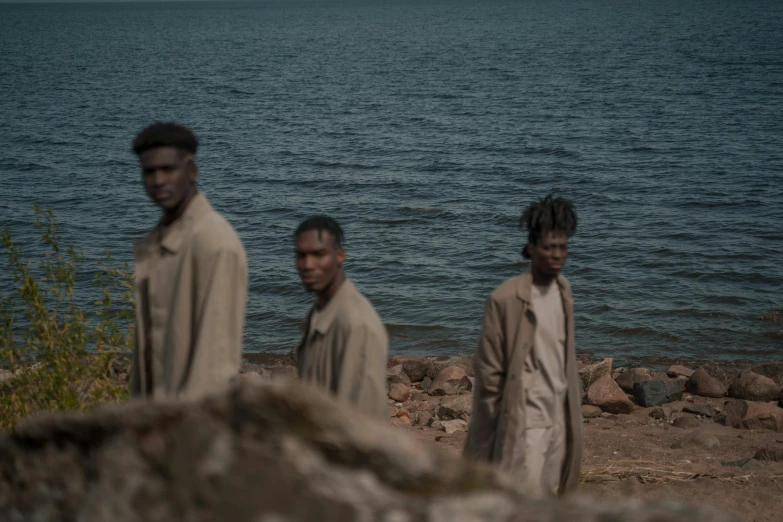 three men standing in front of a body of water, by Matija Jama, les nabis, hbo adaptation, dark complexion, people fleeing, human prisoners