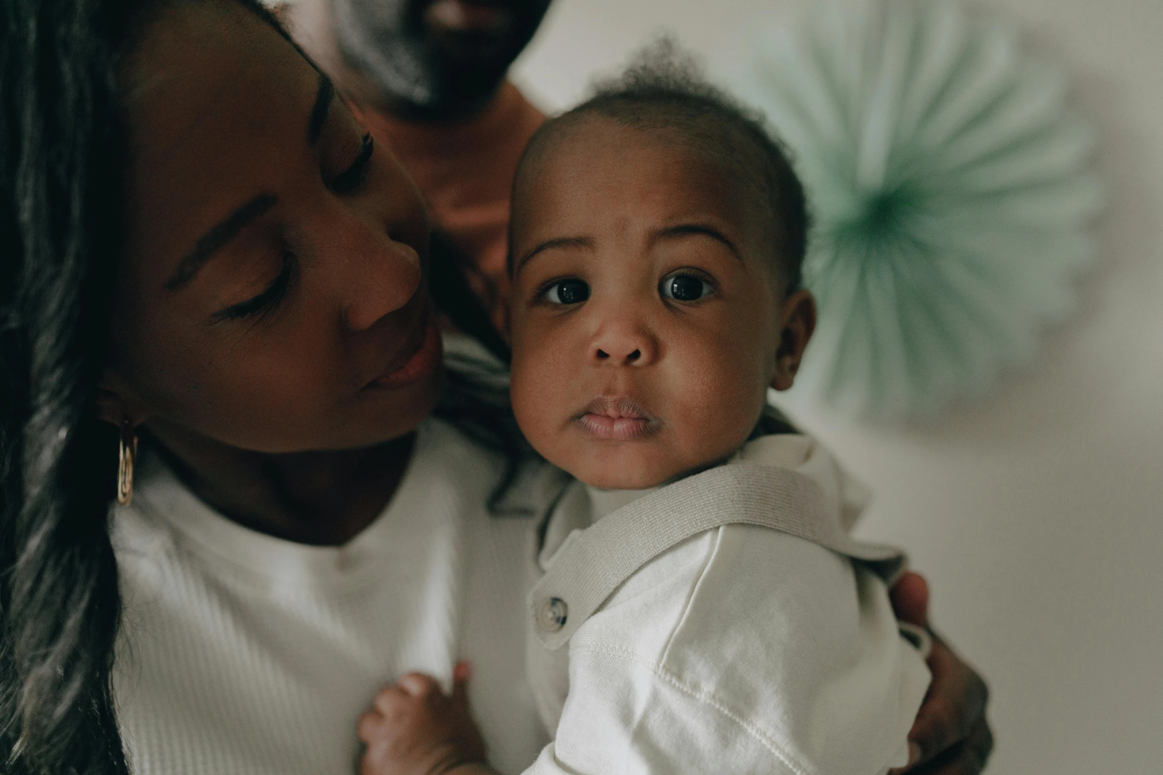 a woman holding a baby in her arms, pexels contest winner, brown skinned, husband wife and son, close up face, uk