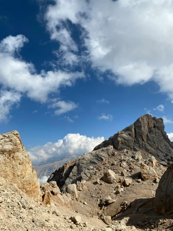 a man flying through the air while riding a snowboard, a picture, unsplash, les nabis, hiking in rocky mountain, 4 k cinematic panoramic view, ceremonial clouds, gravel and scree ground