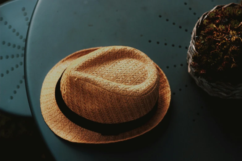 a hat sitting on top of a table next to a potted plant, pexels contest winner, beige fedora, thumbnail, rectangle, miscellaneous objects