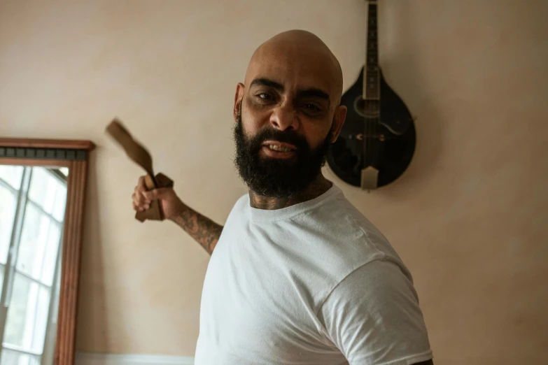 a bald man with a beard holding a knife, pexels contest winner, a portrait of rahul kohli, giant wooden club, aboriginal australian hipster, low quality photo