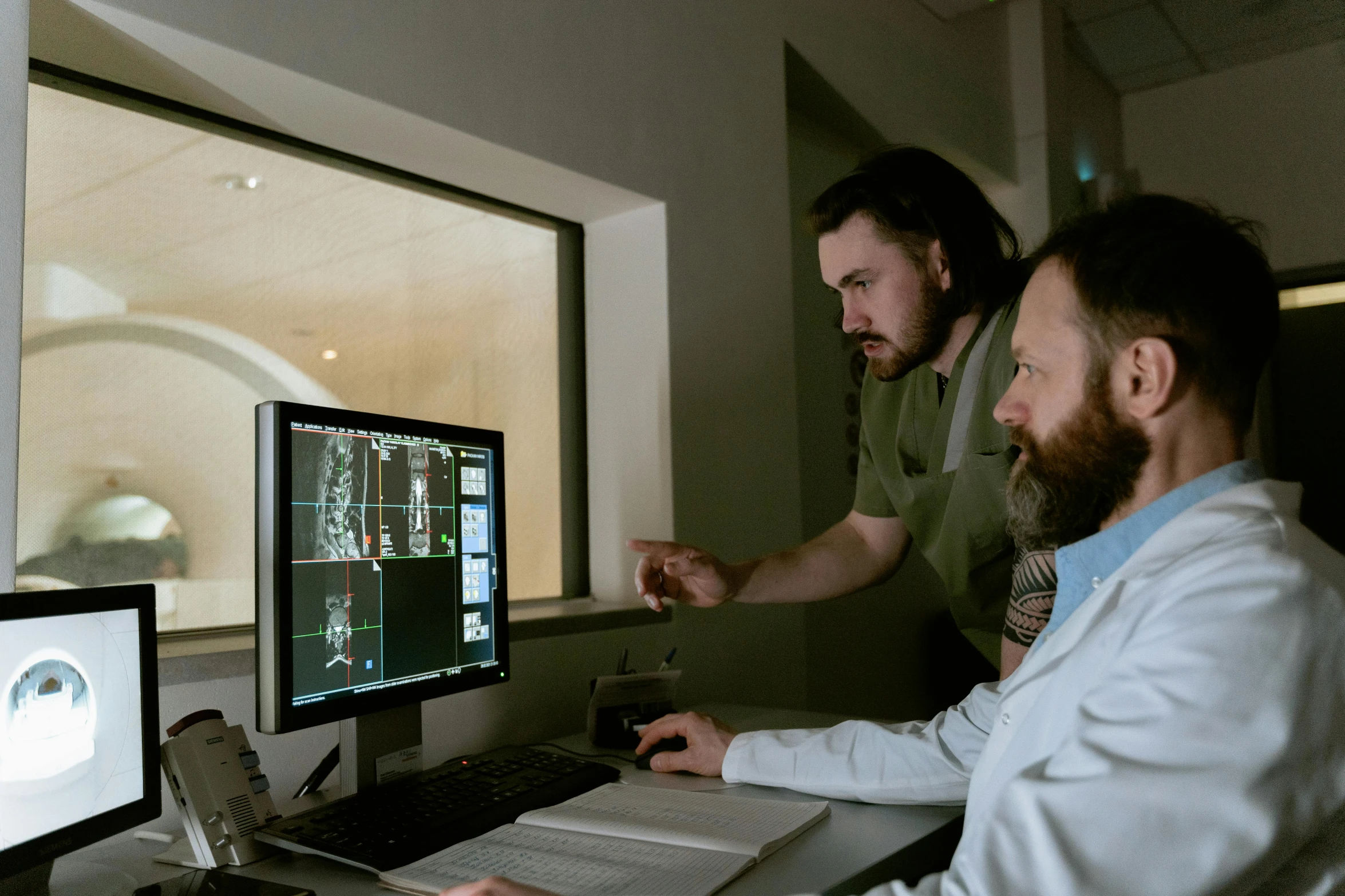two men are looking at a computer screen, weta studios, mri, **cinematic, neil blevins and jordan grimmer