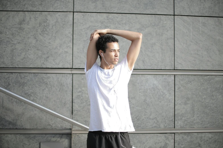 a man with headphones standing in front of a wall, by Adam Rex, pexels contest winner, working out, wearing a light shirt, pointè pose, thumbnail