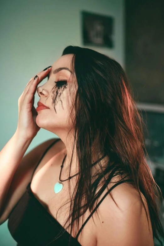 a woman in a black dress holding her hand to her face, an album cover, inspired by Elsa Bleda, trending on pexels, wet dripping long hair, beautiful crying! android woman, profile pic, as she looks up at the ceiling