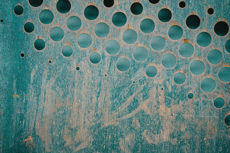 a close up of a wall with holes in it, an album cover, inspired by Max Ernst, unsplash, teal, perforated metal, rustic, circles