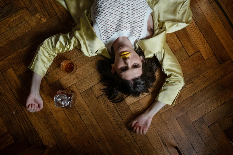 a woman laying on the floor with a banana in her hand, inspired by Elsa Bleda, trending on pexels, renaissance, drinking a glass of whiskey, eleven from stranger things, with yellow cloths, heartbreak