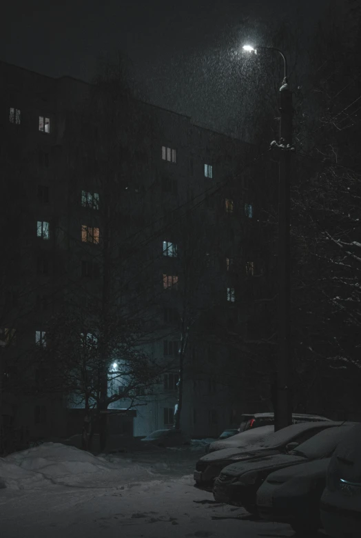 a snow covered parking lot next to a tall building, an album cover, inspired by Elsa Bleda, pexels contest winner, socialist realism, dark neighborhood, soviet apartment building, snowstorm ::5, night view