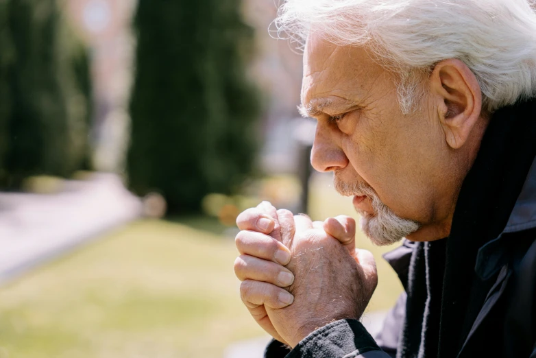 a man sitting on a bench praying, unsplash, portrait of hide the pain harold, profile image, his hands buried in his face, profile picture