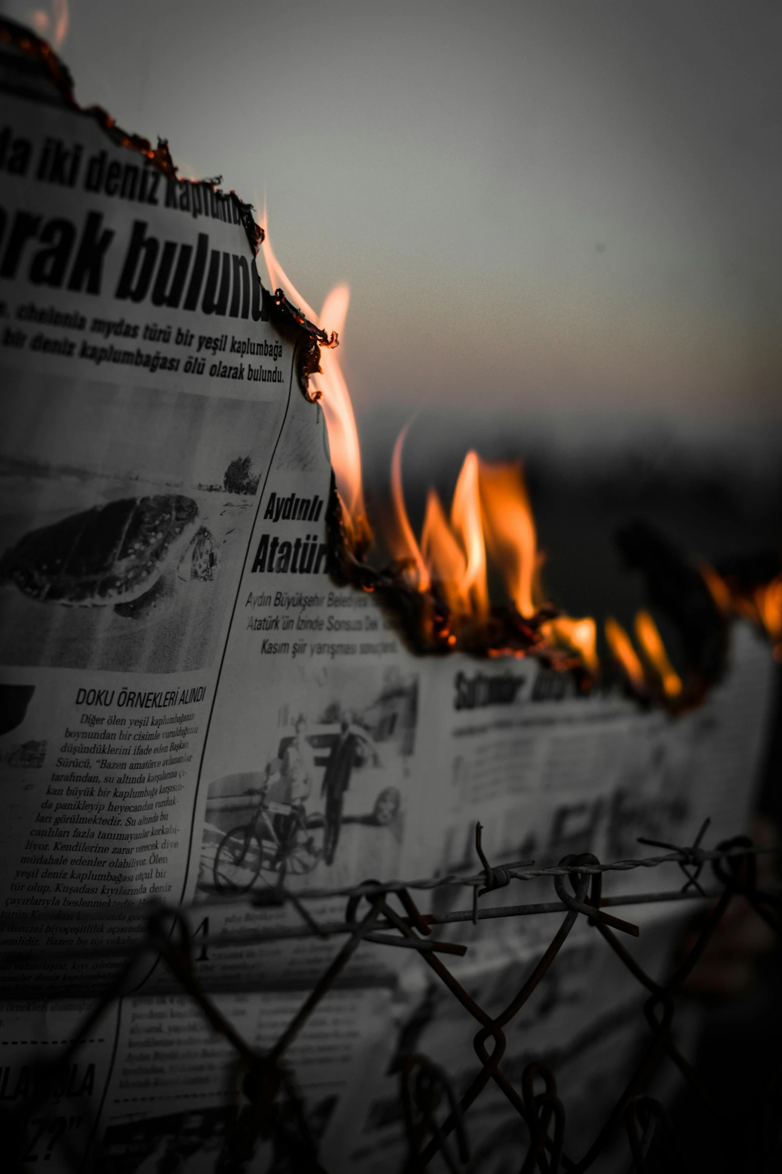 a burning newspaper sitting on top of a fence, a picture, by Ibrahim Kodra, pexels contest winner, fallout style istanbul, fire and brimstone, 2019 trending photo, words