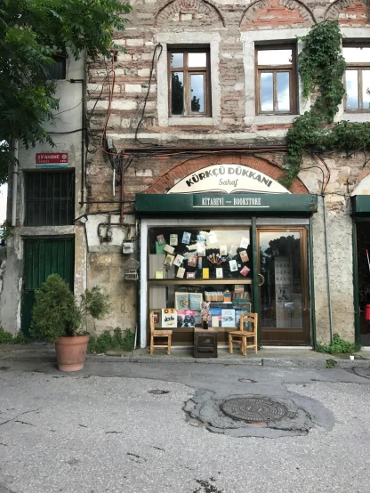 a building with a car parked in front of it, a picture, by Dóra Keresztes, renaissance, bookshops, looks like ebru şahin, a quaint, absolutely