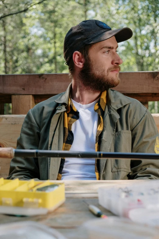 a man sitting on top of a wooden bench, wearing a fisher 🧥, lumberjack flannel, thumbnail, fishing