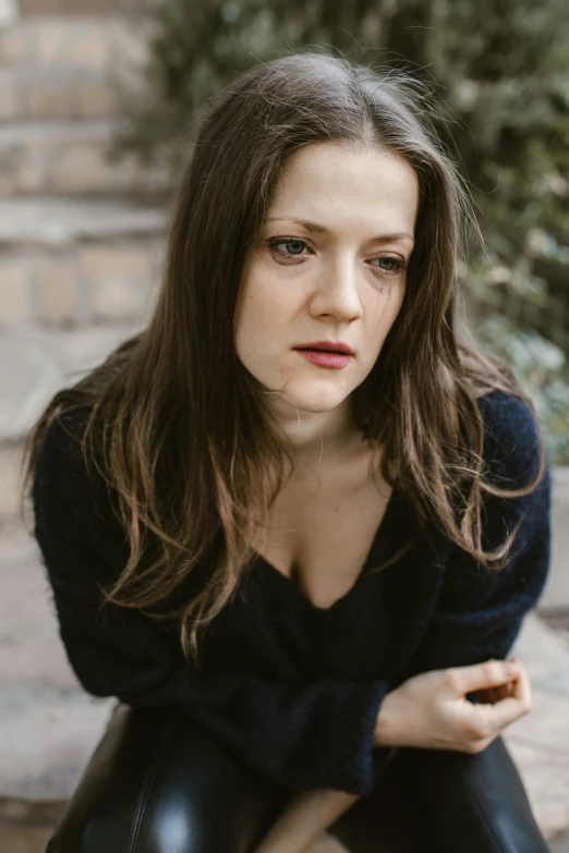 a woman sitting on the steps of a building, an album cover, inspired by Anna Füssli, unsplash, renaissance, elisabeth moss, serious face, dark backdrop, on a tree