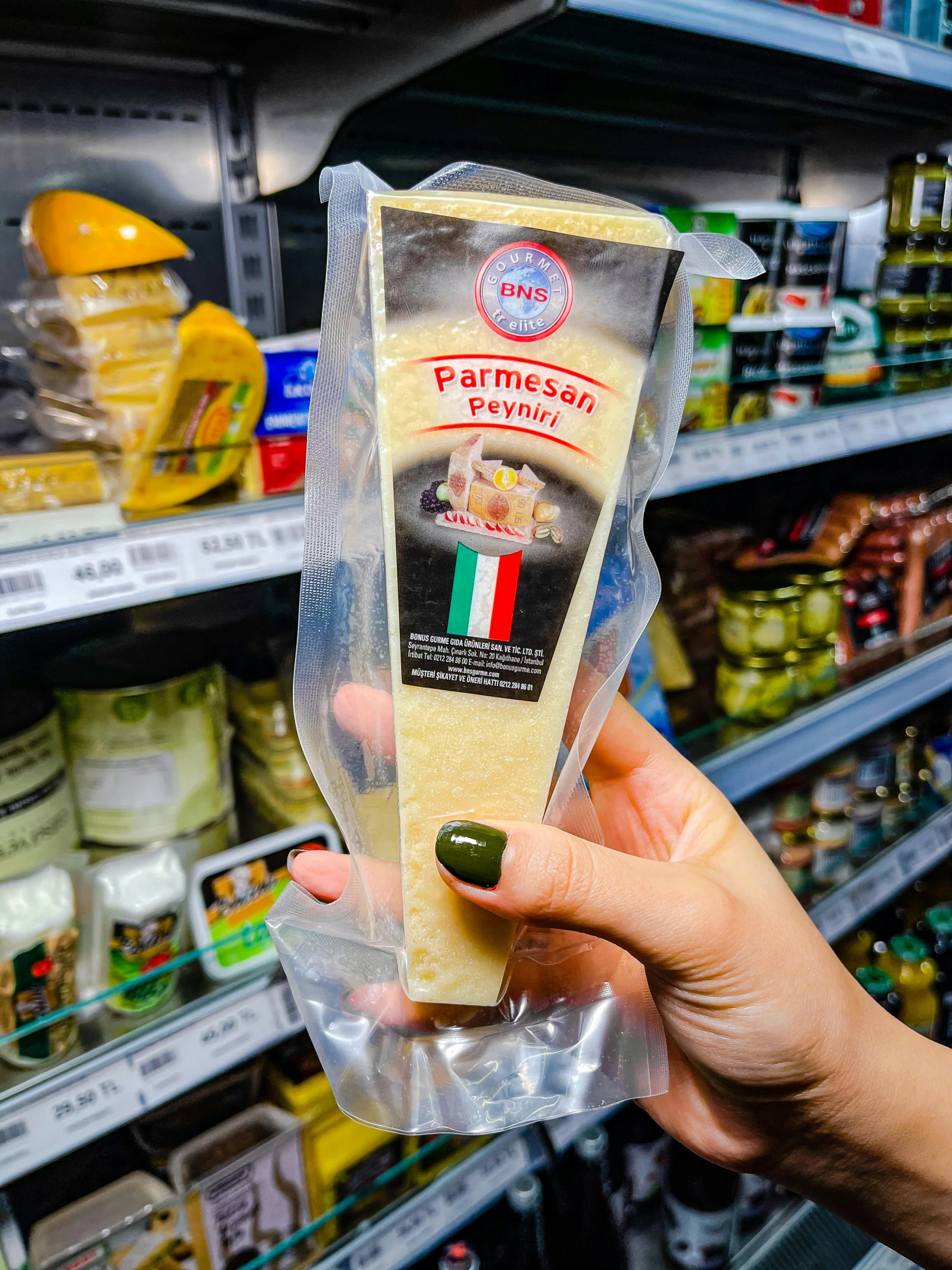 a person holding a piece of cheese in a store, svetlana tigai, high quality product image”, in plastic, naples