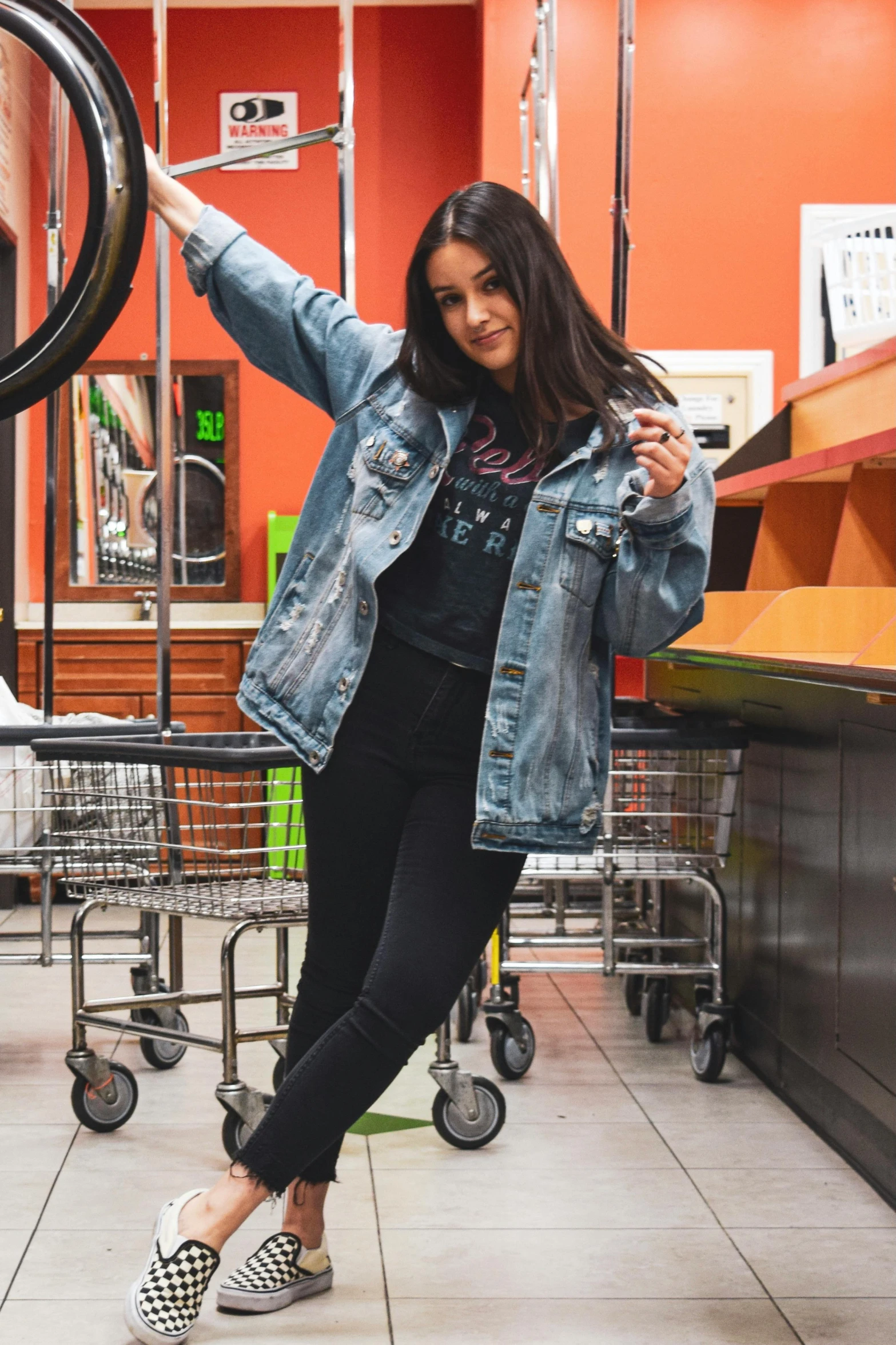 a woman holding up a tire in a store, pexels contest winner, graffiti, wearing a jeans jackets, female camila mendes, ((in a super market costco)), portrait full body