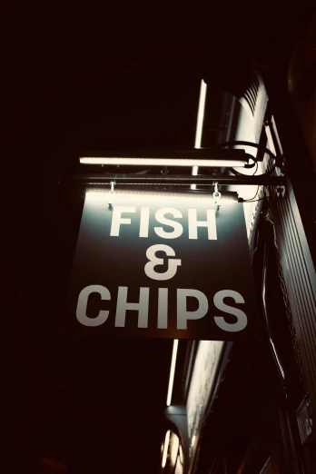 a fish and chips sign hanging from the side of a building, an album cover, unsplash, sepia, nightlife, computer chips, high quality photo