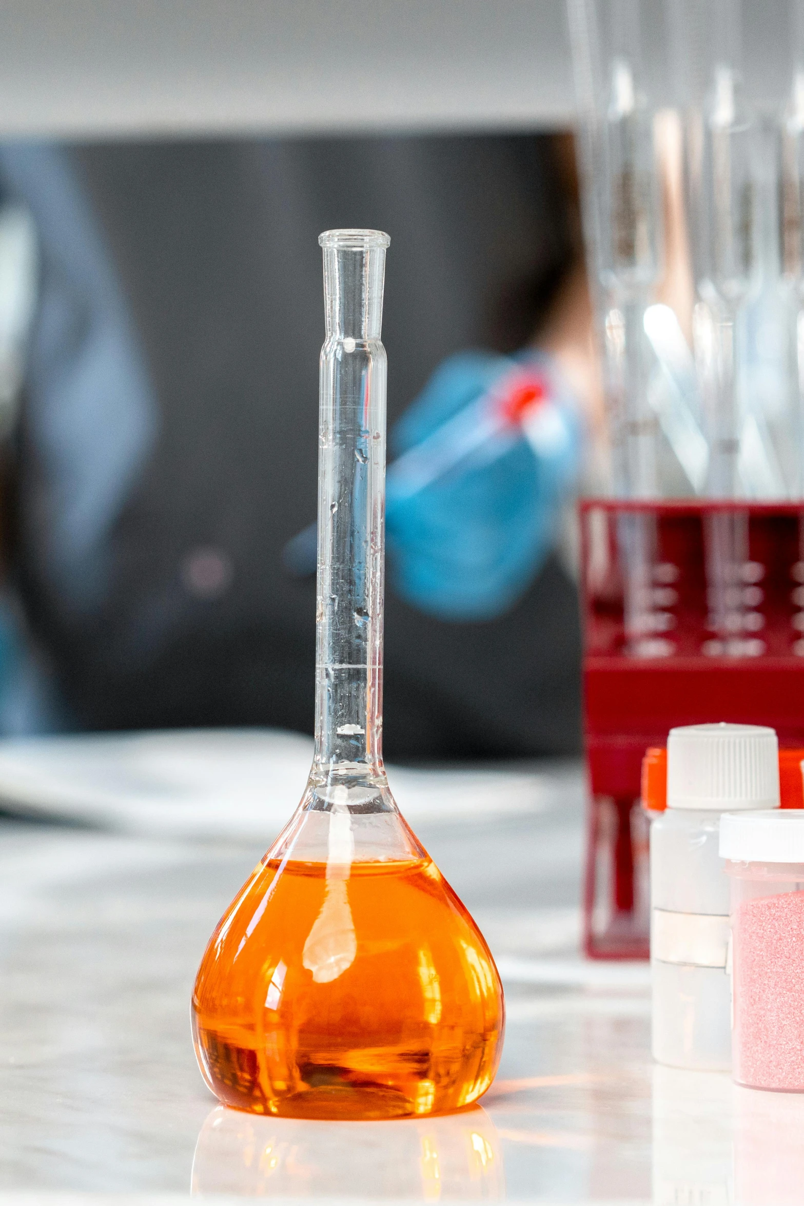 a close up of a bottle of liquid on a table, a portrait, shutterstock, tools for science research, plating, red liquid, beaker