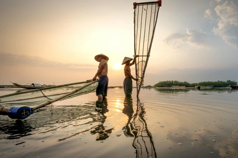 a couple of men standing on top of a body of water, by Jan Tengnagel, pexels contest winner, farming, asian sun, netting, slide show