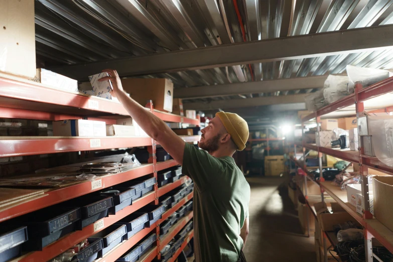 a man working on a shelf in a warehouse, vollumetric lighting, lachlan bailey, avatar image, customers