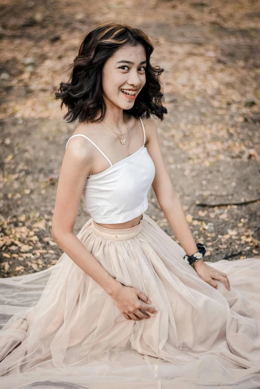 a woman sitting on the ground in a dress, inspired by Juliette Leong, pexels contest winner, detailed smile, wearing crop top, 🤤 girl portrait, 15081959 21121991 01012000 4k