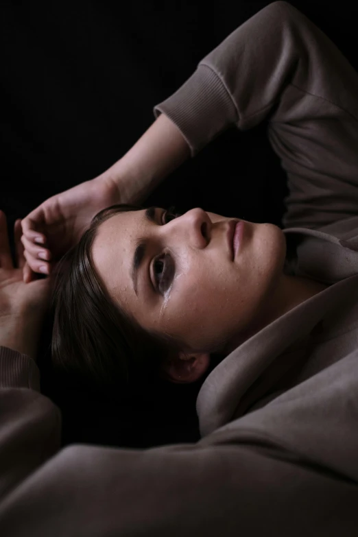 a woman laying in bed with a remote in her hand, a portrait, inspired by Anna Füssli, trending on pexels, hyperrealism, androgynous face, crawling out of a dark room, video still, androgynous person