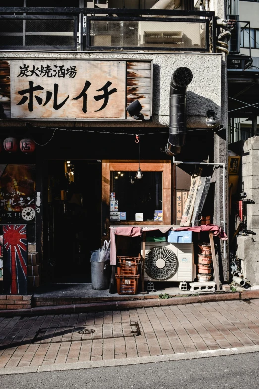 a man riding a motorcycle down a street past a store, an album cover, by Sengai, unsplash, old signs, crafts and souvenirs, けもの, tools and junk on the ground