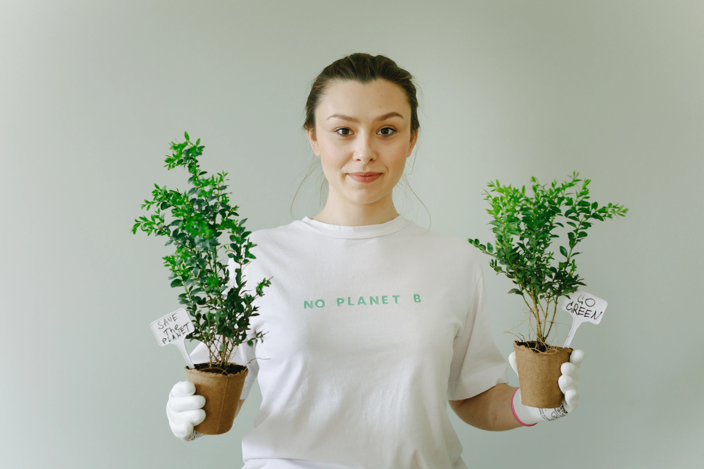 a woman in a white shirt holding two potted plants, pexels contest winner, wearing a t-shirt, avatar image, future activist, sea - green and white clothes