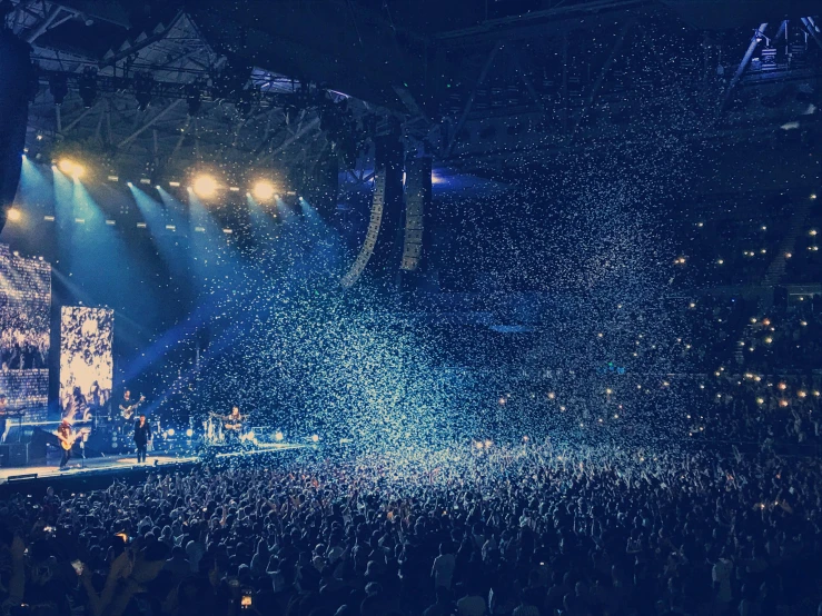 a large crowd of people at a concert, pexels contest winner, petals falling everywhere, in the middle of an arena, blue mood, dua lipa