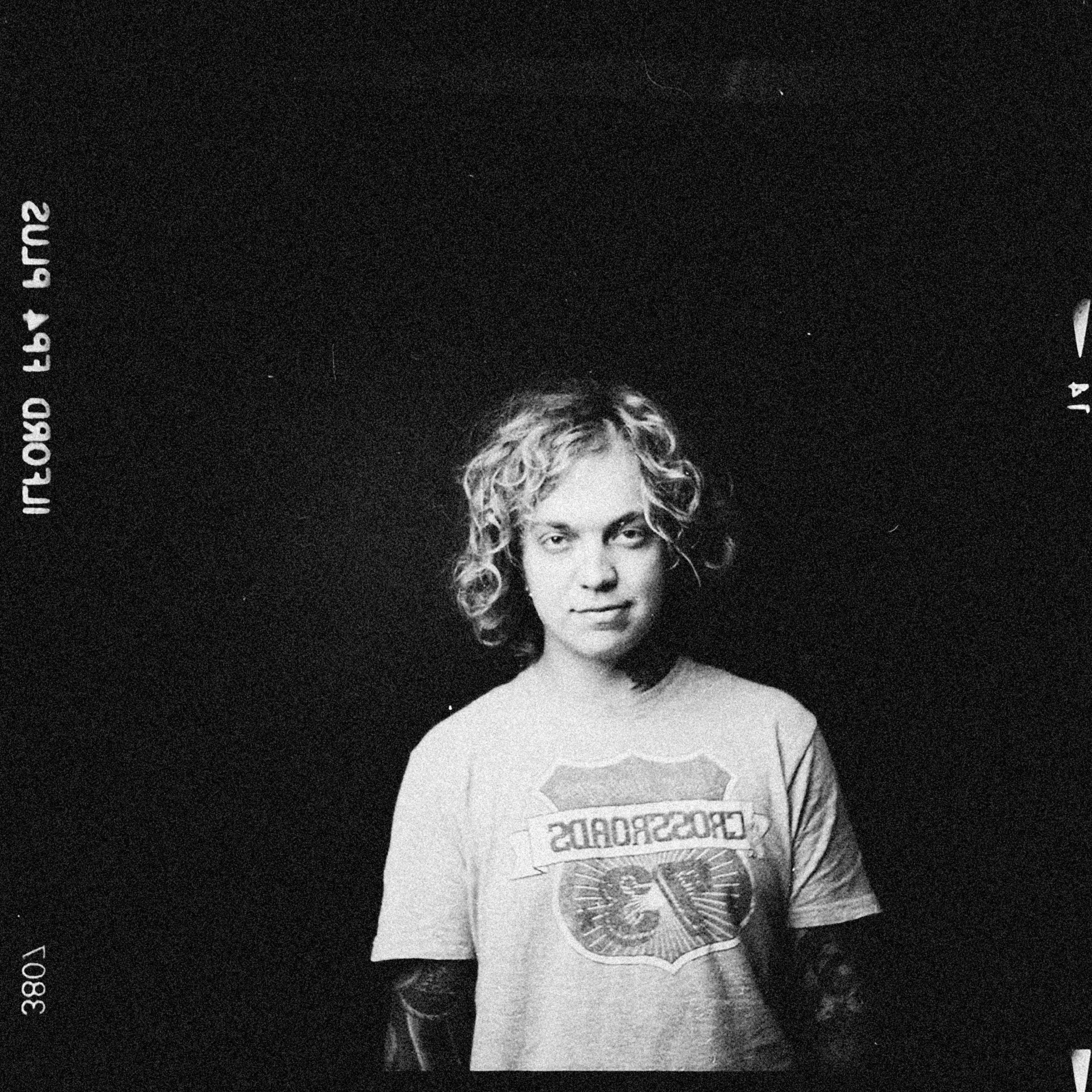 a black and white photo of a woman in a t - shirt, a black and white photo, inspired by Lasar Segall, curly blonde hair, blonde man, fujicolor with flash, ryan kiera armstrong