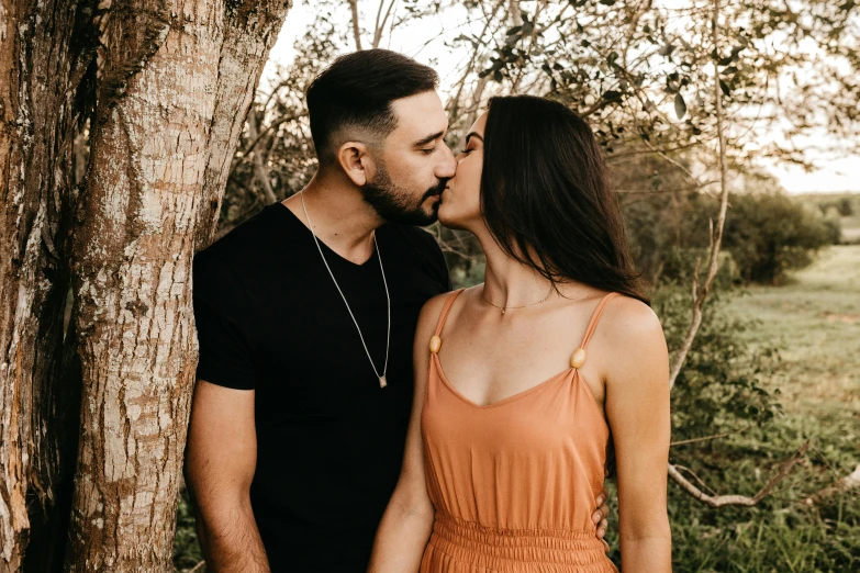 a man kissing a woman in front of a tree, pexels contest winner, pokimane, profile image, bearded, background image