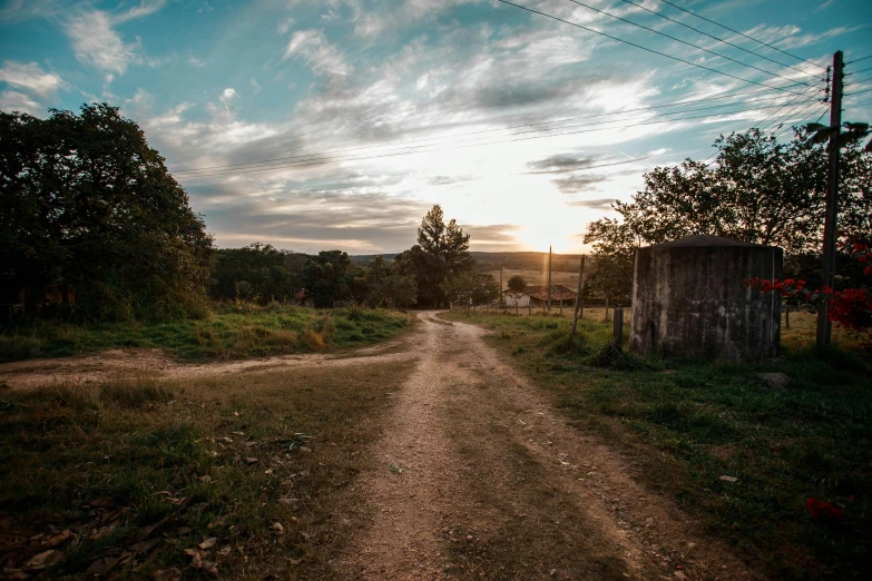 a dirt road in the middle of a field, by Adam Szentpétery, pexels contest winner, st cirq lapopie, late afternoon, in a village, uncropped