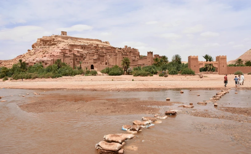 a group of people walking across a river, les nabis, in a dusty red desert, villages castles, maintenance photo, teaser