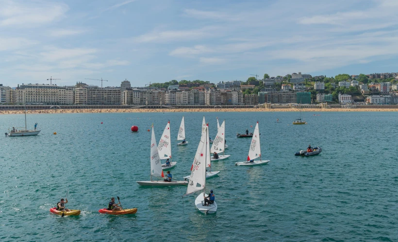 a number of small sailboats on a body of water, shutterstock, figuration libre, the sea seen behind the city, sports setting, ignant, spain