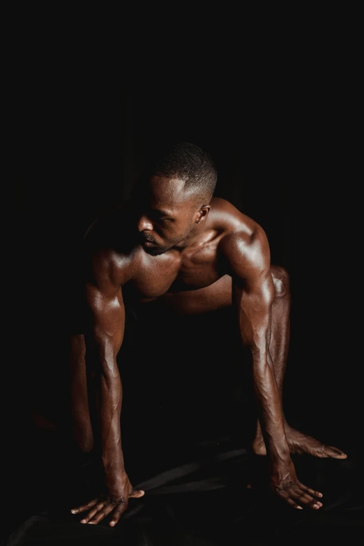 a man doing a handstand pose in the dark, an album cover, by Jessie Alexandra Dick, hyperrealism, showing off his muscles, brown skin like soil, kneeling, looking sad