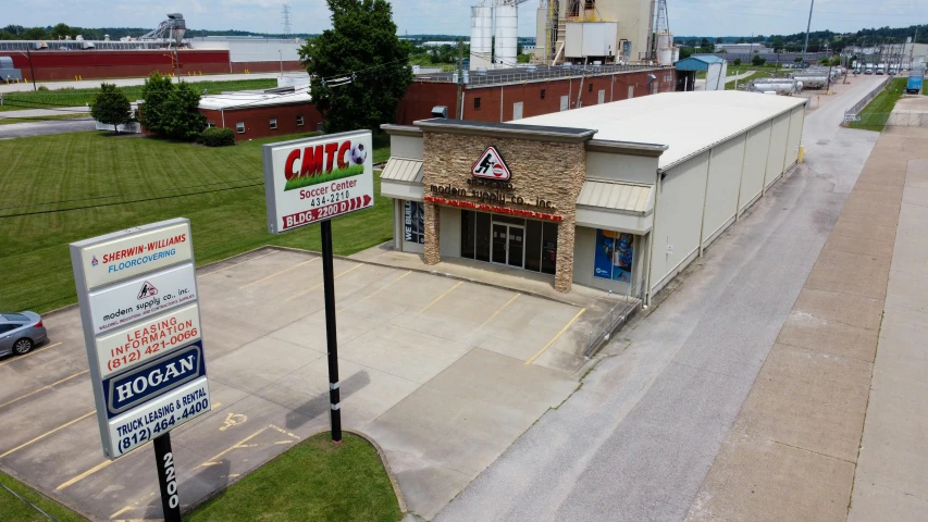 a building with a sign in front of it, tn, arial shot, old cmputers on the sidewalk, truss building