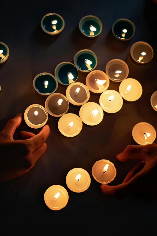 a group of people lighting candles in the dark, photograph from above, serene lighting, sun lit, rip