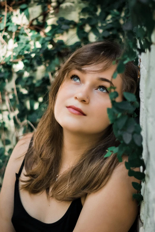 a beautiful young woman leaning against a wall, an album cover, by Adam Marczyński, unsplash, renaissance, green eyes fine face pretty face, joey king, in a tree, headshot profile picture