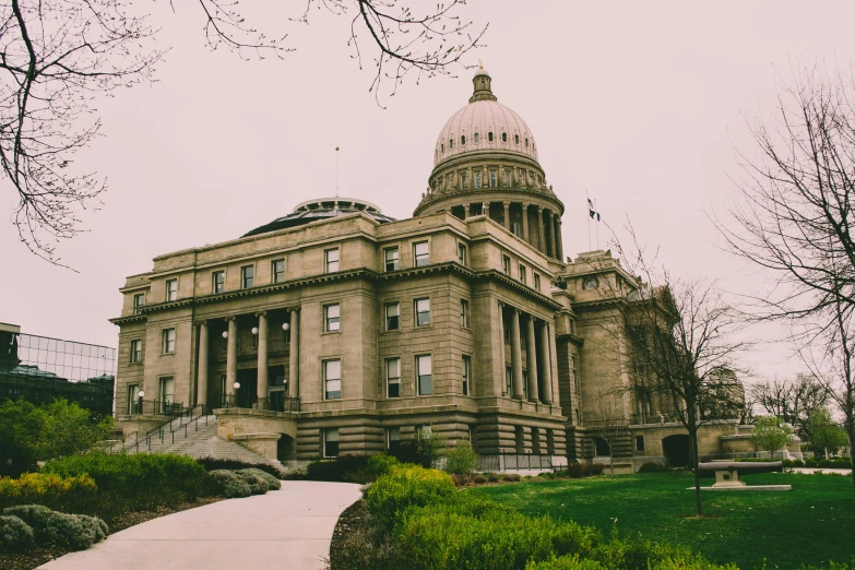 a large building sitting on top of a lush green field, unsplash contest winner, capitol building, idaho, nice slight overcast weather, 90s photo